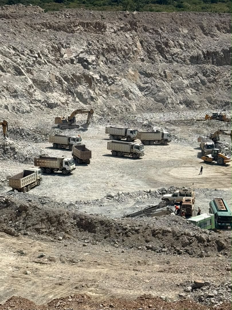 Fosse de mine à ciel ouvert avec pelles et camions en chargement